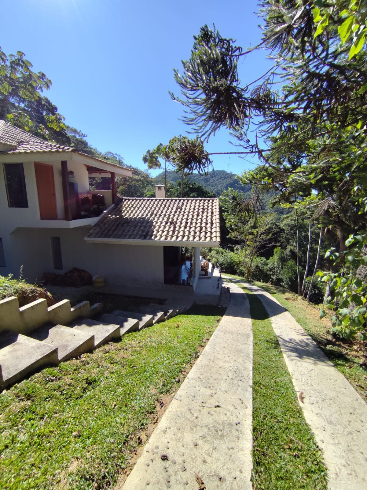Terreno de encosta com mata preservada ao fundo, na área de estudo